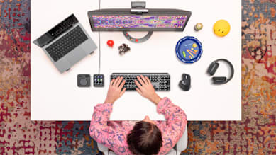 Man working at a desk using Logitech MX Master 4 mouse and other Logitech devices